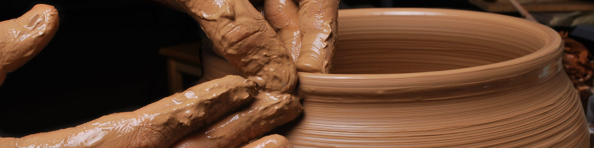 Person molding a jar on a pottery wheel