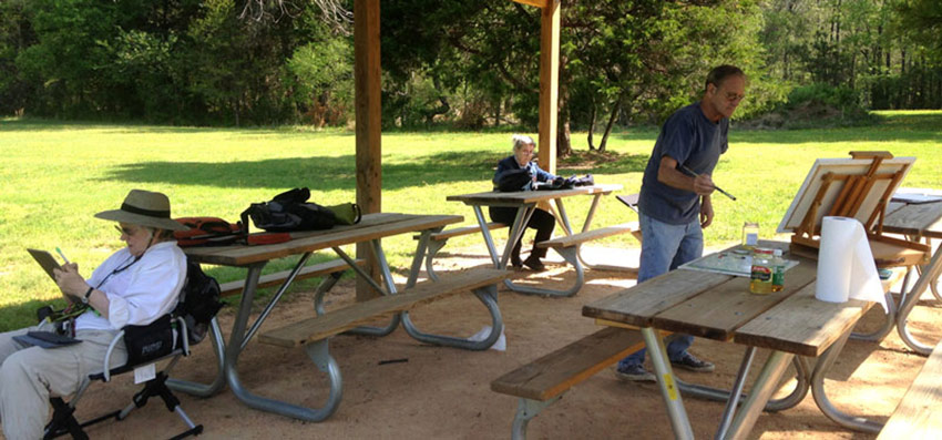 Louise Nerys and Fred Painting outside under a pavilion