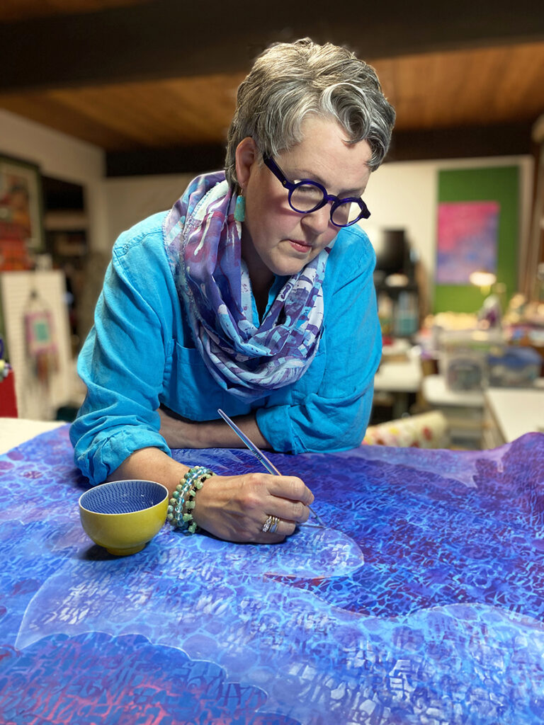 Artist Susan Brubaker Knapp working on one of her art quilts in her studio